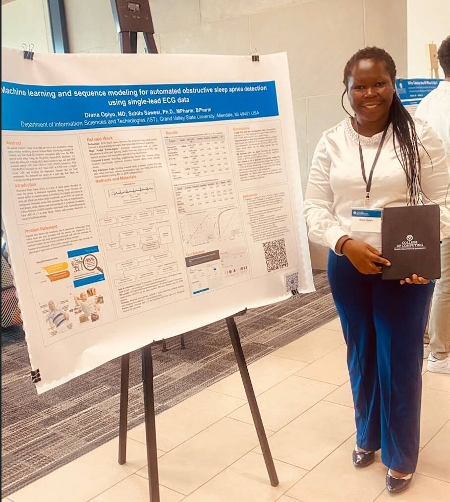 Diane Opiyo stands with her award winning poster at Tech Week Grand Rapids 2026
